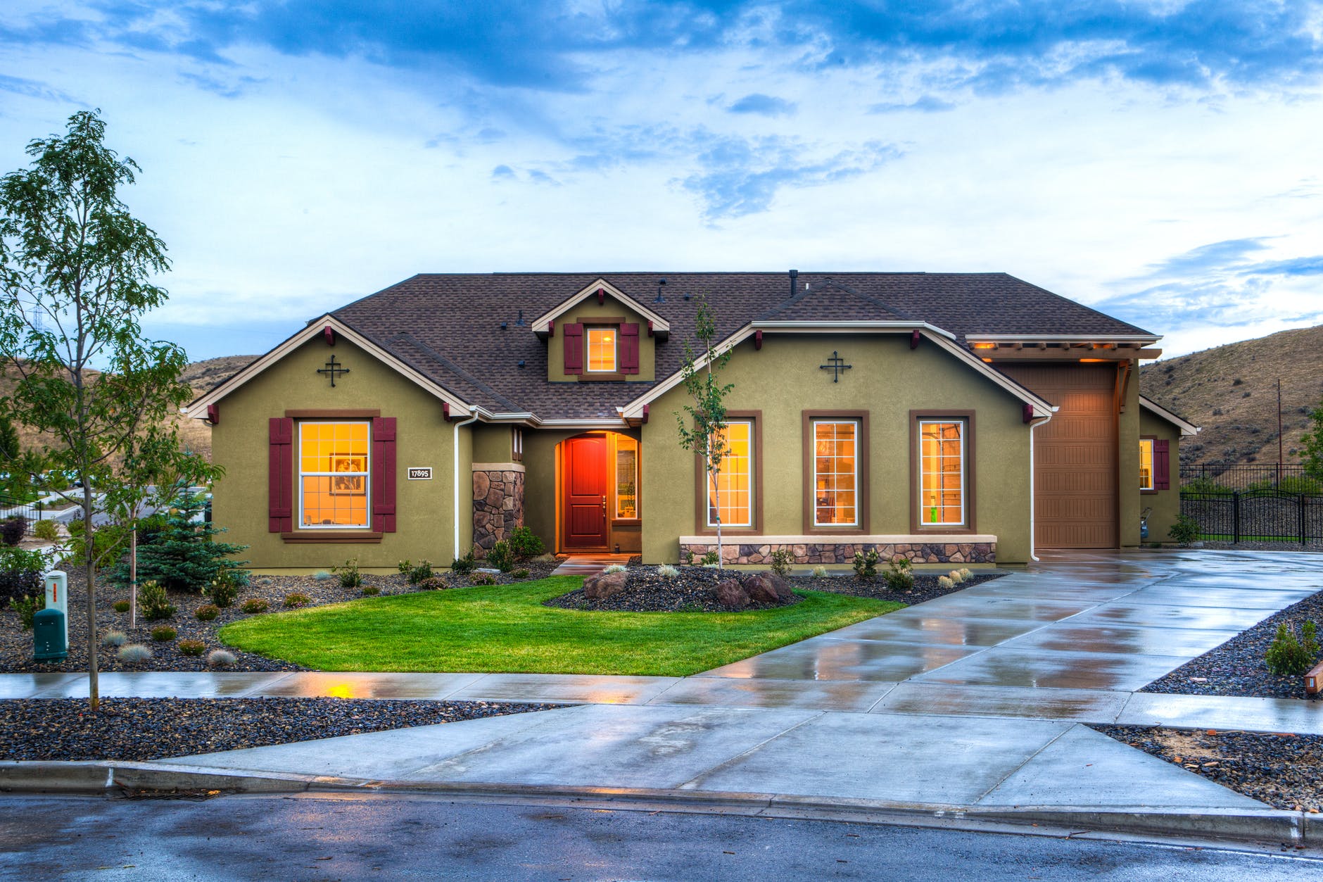 A welcoming home with a landscaped front yard at dusk