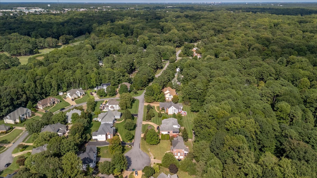 Drone view showing homes nestled among trees in the neighborhood