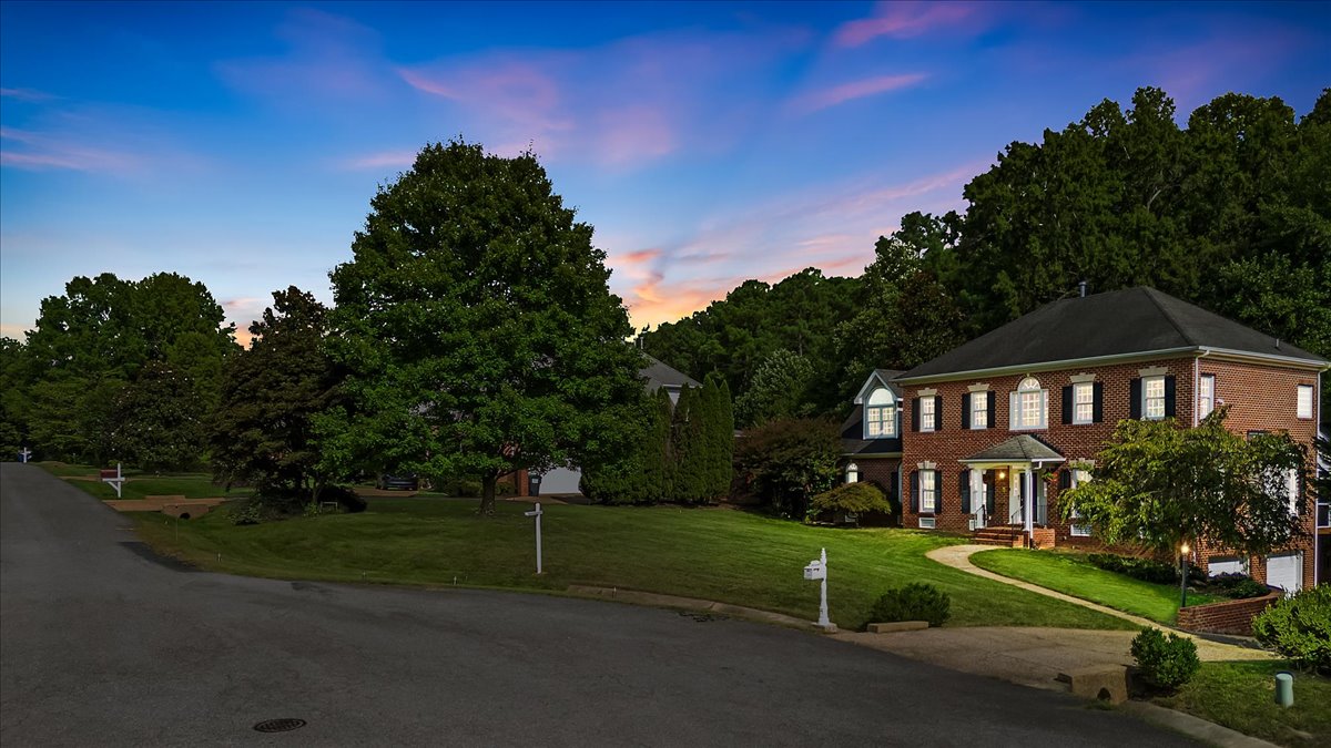Brick home presented with a twilight sky and illuminated windows